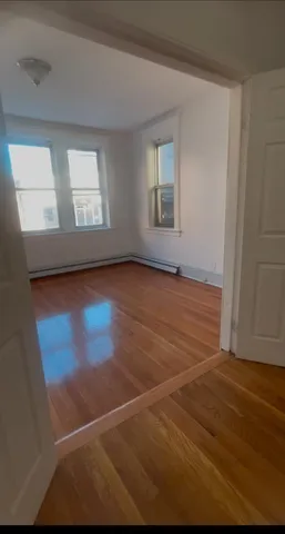 an empty room with wooden floor and a window