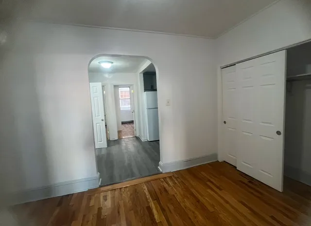 a view of an empty room with wooden floor