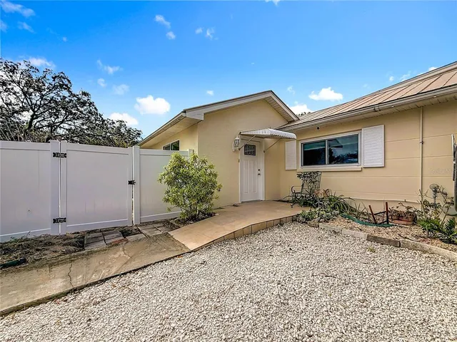 a view of a house with a yard and large tree