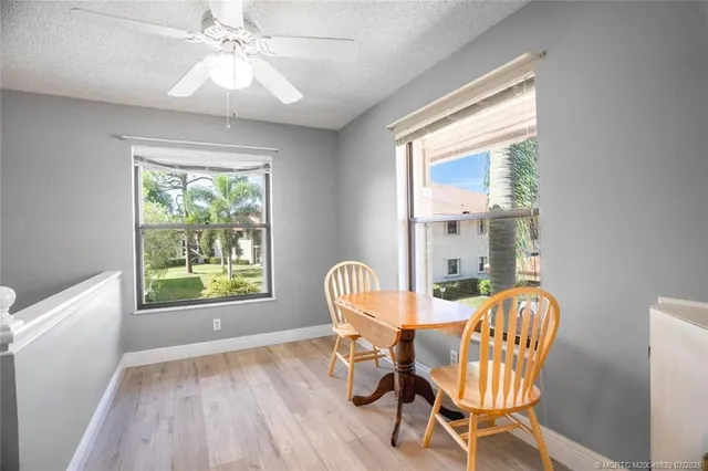a dining room with furniture a chandelier and wooden floor