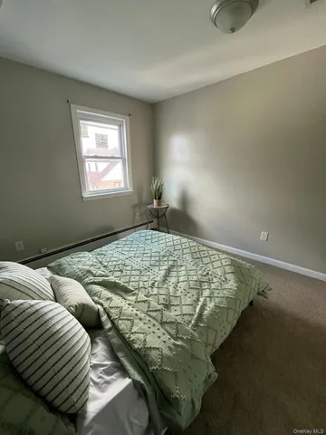 a bed sitting in a bedroom next to a wooden cabinet