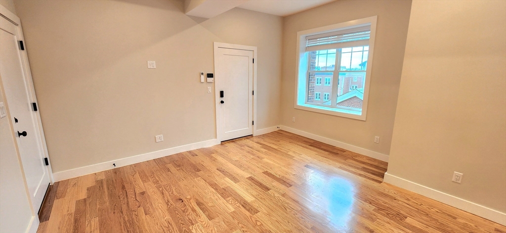 58 Lubec Street, Unit 8 Boston, MA 02128 - Photo 6 of 16 a view of empty room with wooden floor and fan
