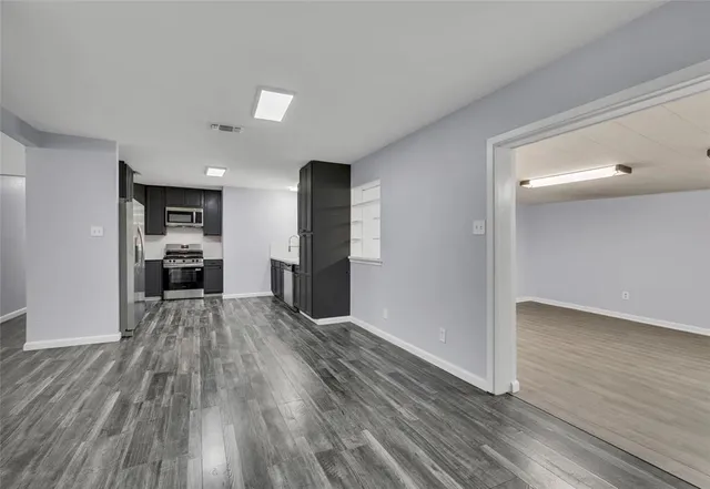 a view of a kitchen with wooden floor and electronic appliances