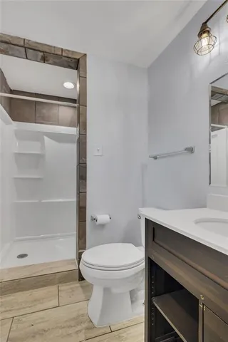 a bathroom with a toilet a sink and shower