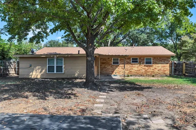 a view of a small space in front of a yard with wooden fence