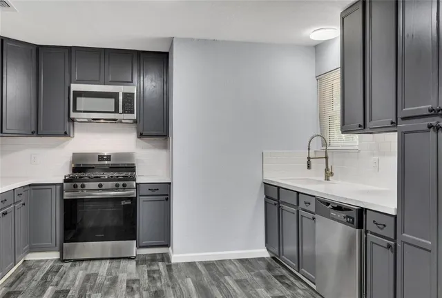 a kitchen with stainless steel appliances a sink stove and refrigerator