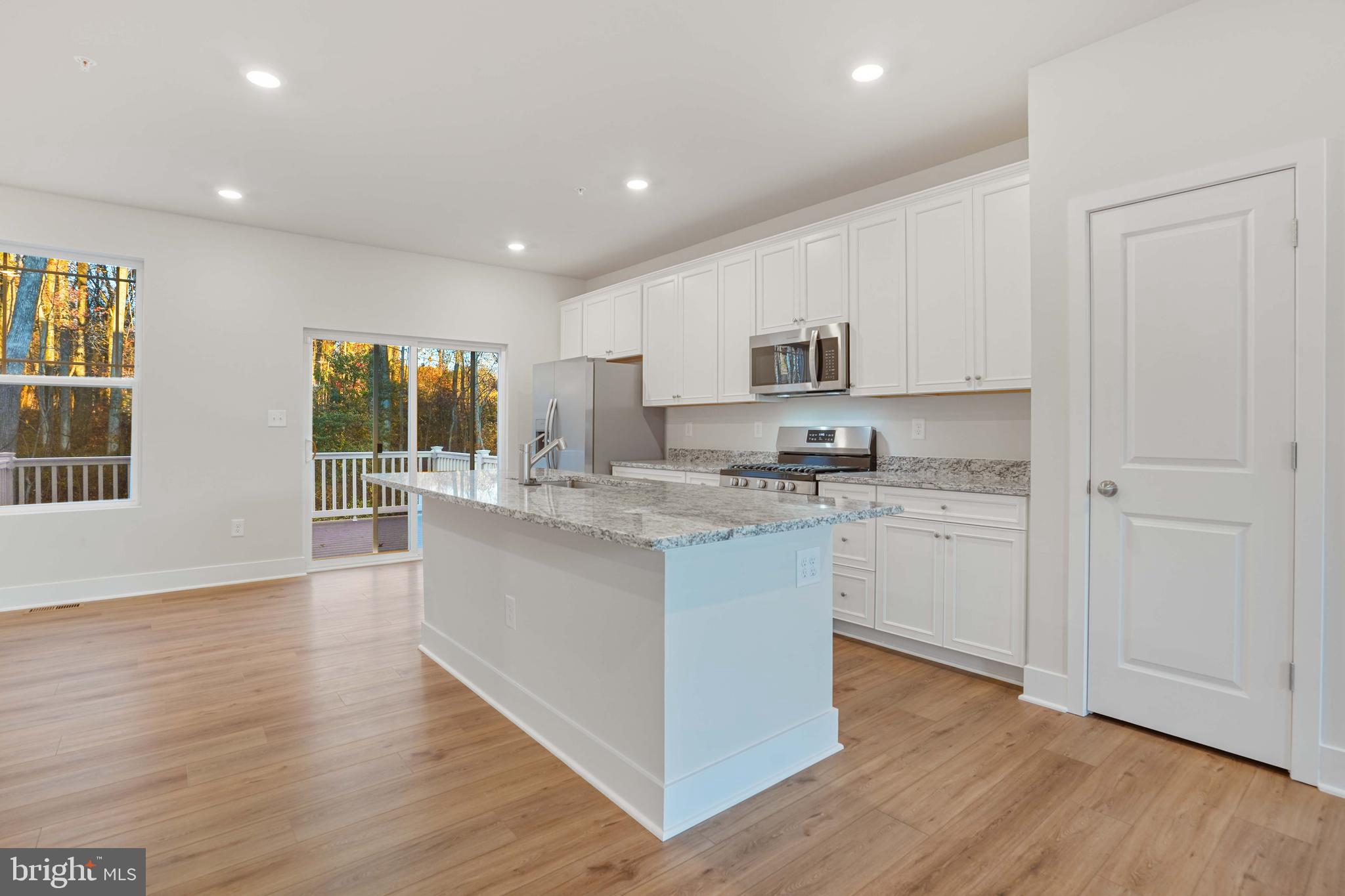 252 Waterstone Road Essex, MD 21221 - Photo 13 of 35 a kitchen with granite countertop white cabinets and white appliances
