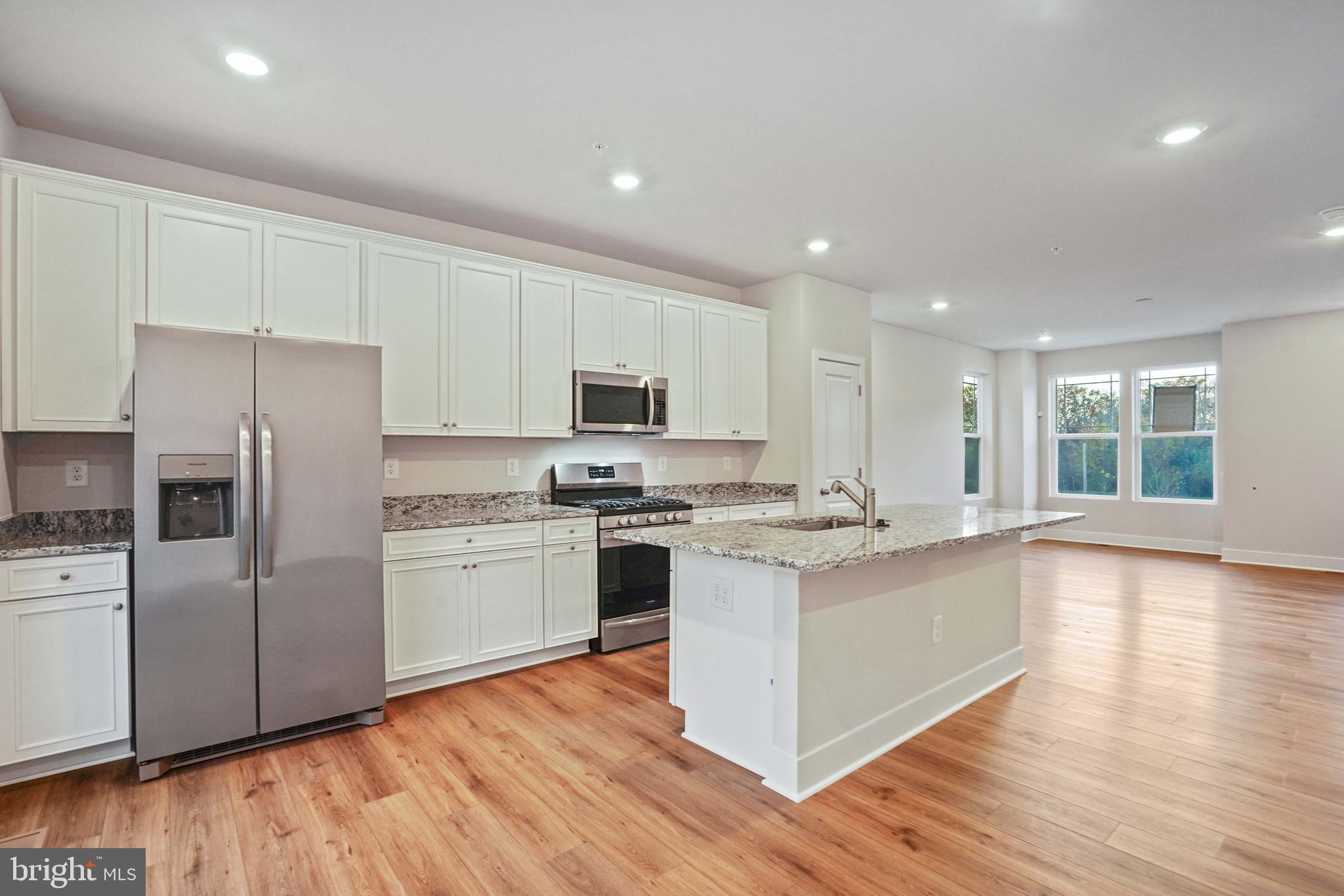 252 Waterstone Road Essex, MD 21221 - Photo 9 of 35 a kitchen with white cabinets and stainless steel appliances