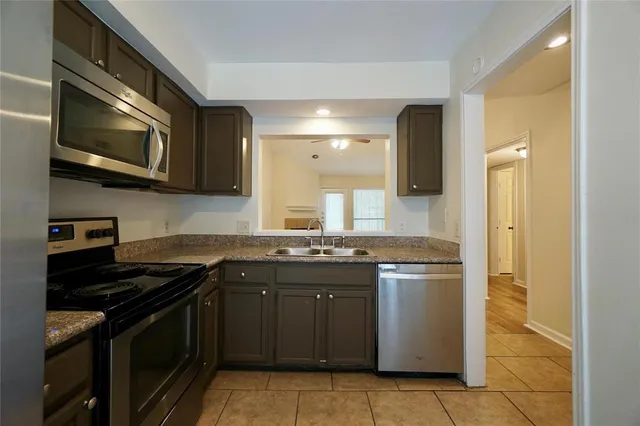 a kitchen with stainless steel appliances granite countertop a stove and a microwave