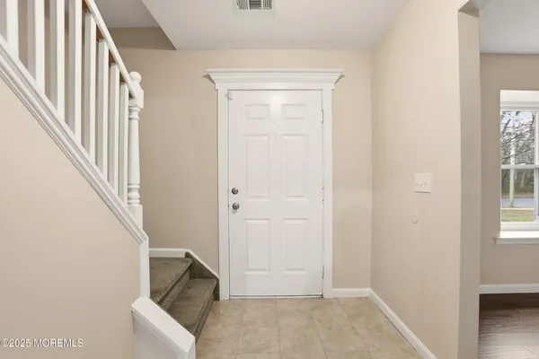 an entryway with a white walls and stairs
