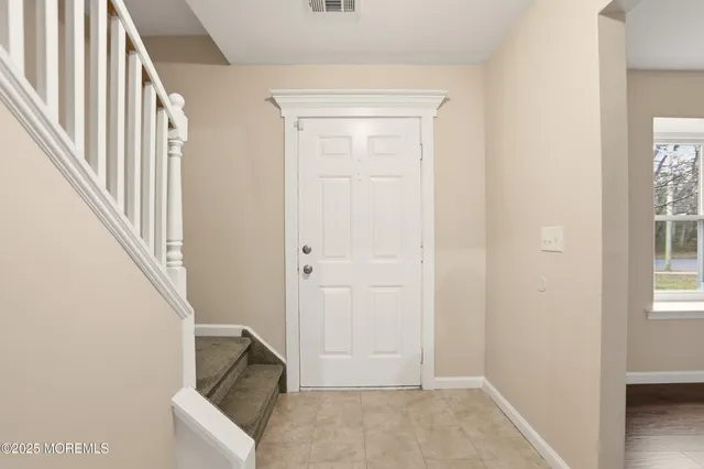 an entryway with a white walls and stairs