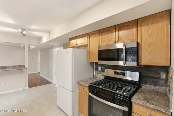 a kitchen with a stove a refrigerator and a microwave