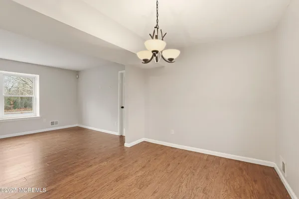 a view of a room with wooden floor and windows