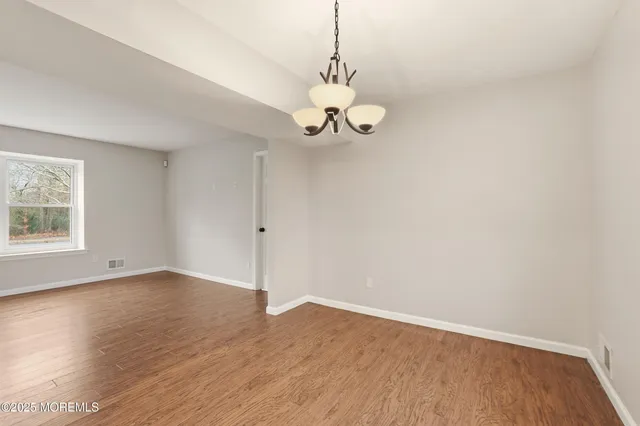 a view of a room with wooden floor and windows