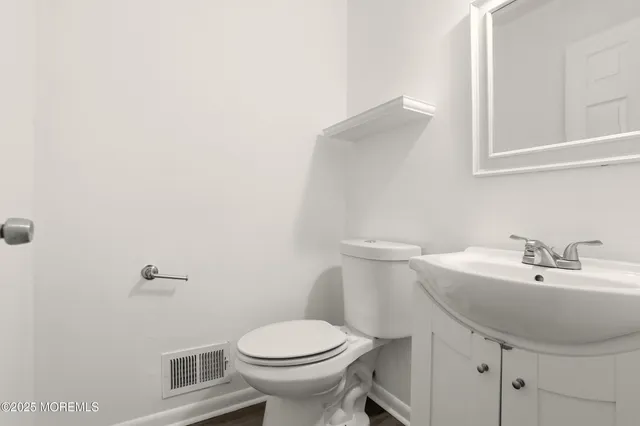 a bathroom with a sink a toilet and mirror