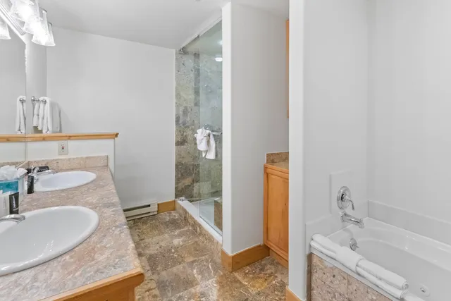 a bathroom with a granite countertop sink a toilet and shower