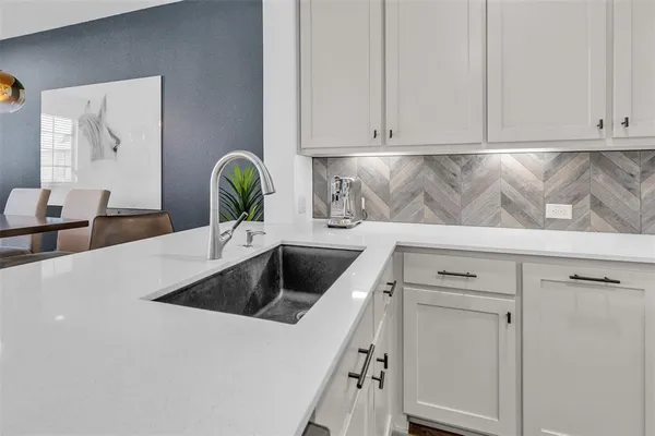 a kitchen with counter top space a sink appliances and cabinets