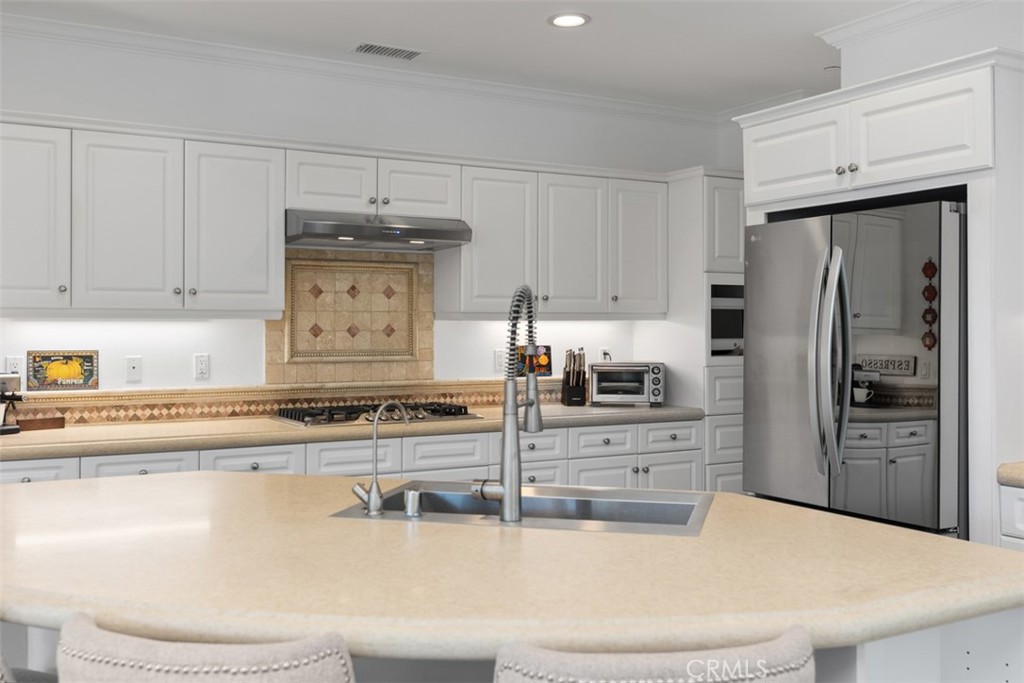 2 Via Paquete San Clemente, CA 92673 - Photo 19 of 44 a kitchen with stainless steel appliances granite countertop a refrigerator a stove and white cabinets