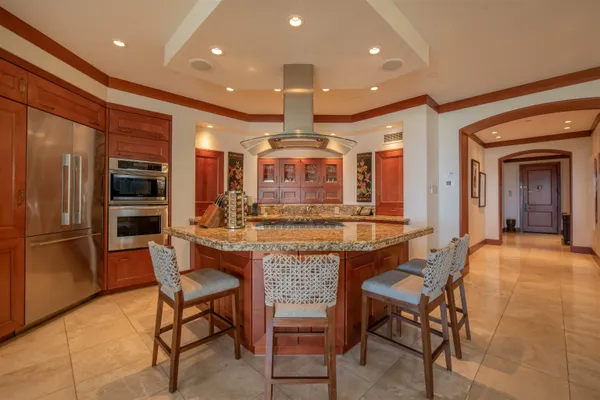a view of a dining room with furniture a kitchen and chandelier