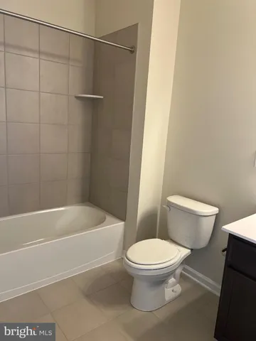 a white toilet sitting next to a bath tub and a shower