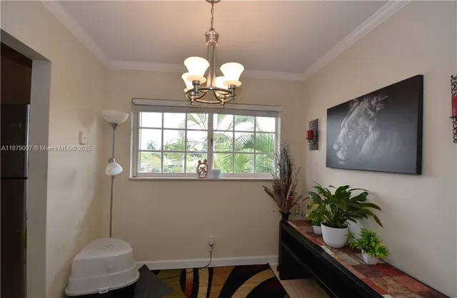 a dining room with furniture a potted plant and a chandelier