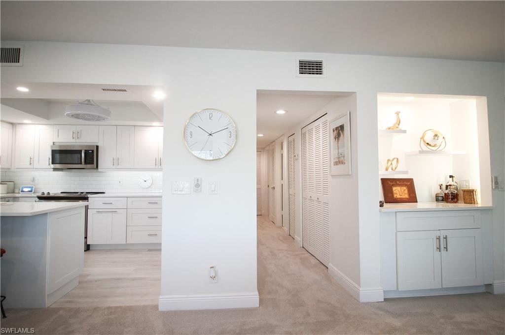 97 Georgetown Boulevard, Unit 97 Naples, FL 34112 - Photo 7 of 26 a kitchen with cabinets and wooden floor