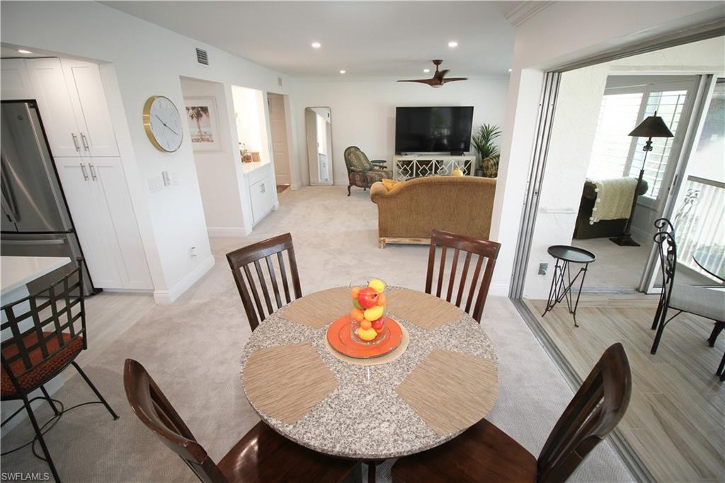 97 Georgetown Boulevard, Unit 97 Naples, FL 34112 - Photo 9 of 26 a living room with furniture and a flat screen tv