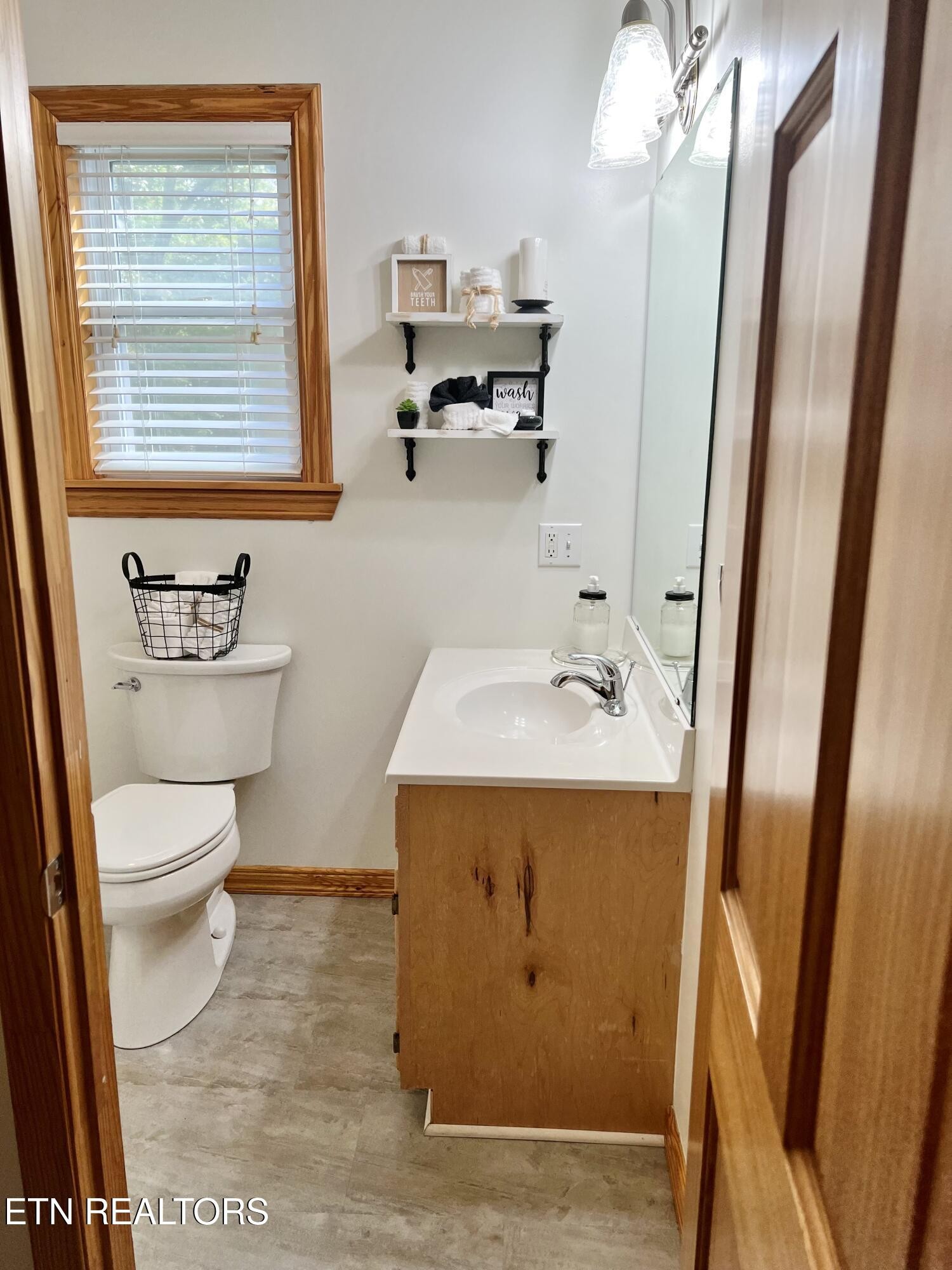 186 Perkins Trail Deer Lodge, TN 37726 - Photo 23 of 54 a bathroom with a sink a toilet and mirror