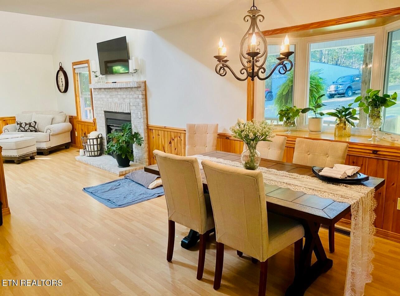 186 Perkins Trail Deer Lodge, TN 37726 - Photo 27 of 54 a view of a dining room with furniture a fireplace and wooden floor