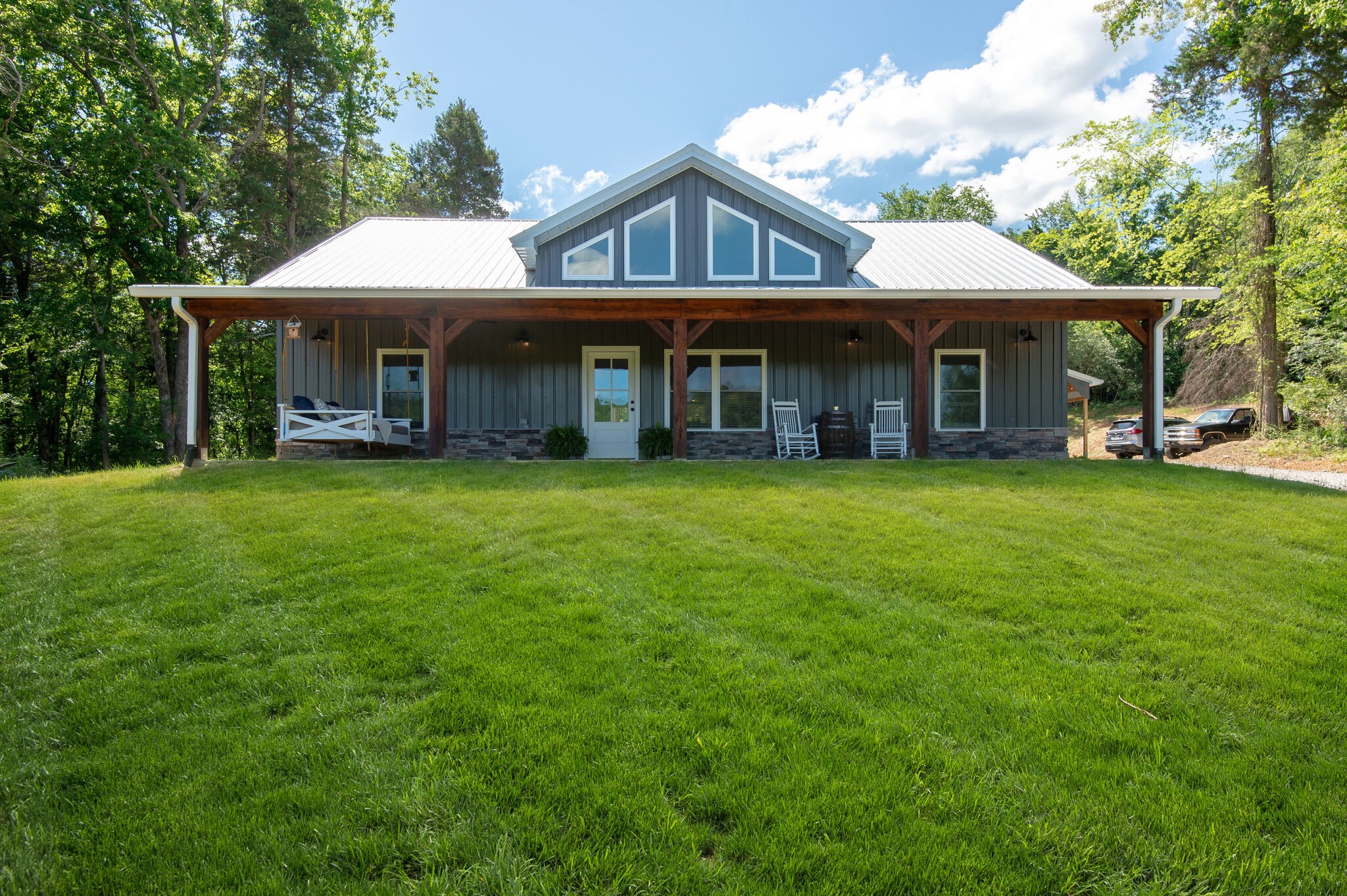 a view of a big house with a big yard and large trees