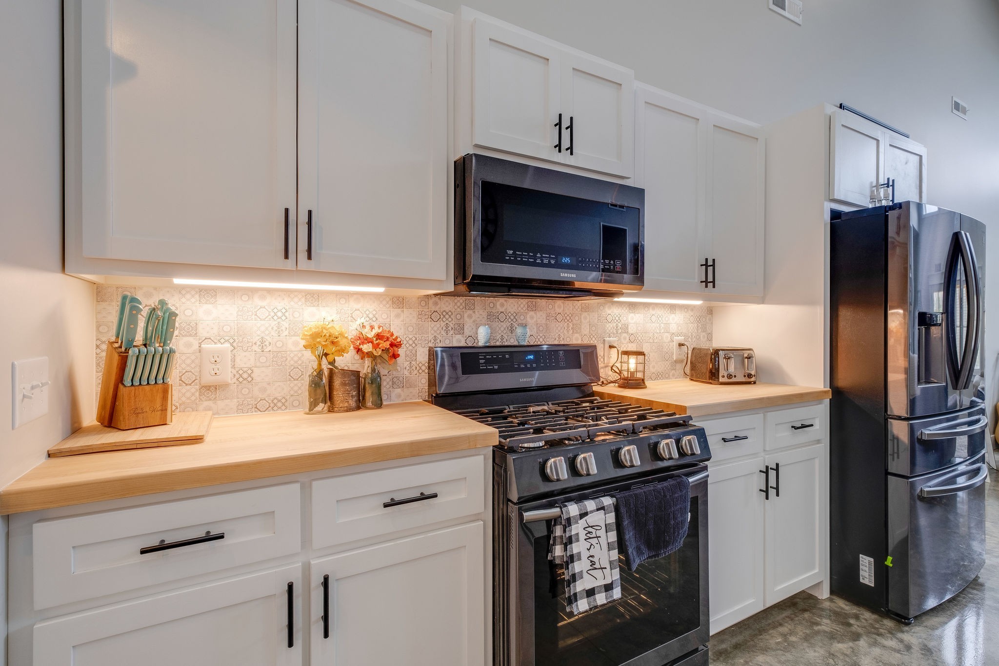 1495 Columbia Road Charlotte, TN 37036 - Photo 11 of 50 a kitchen with stainless steel appliances a stove a microwave and refrigerator