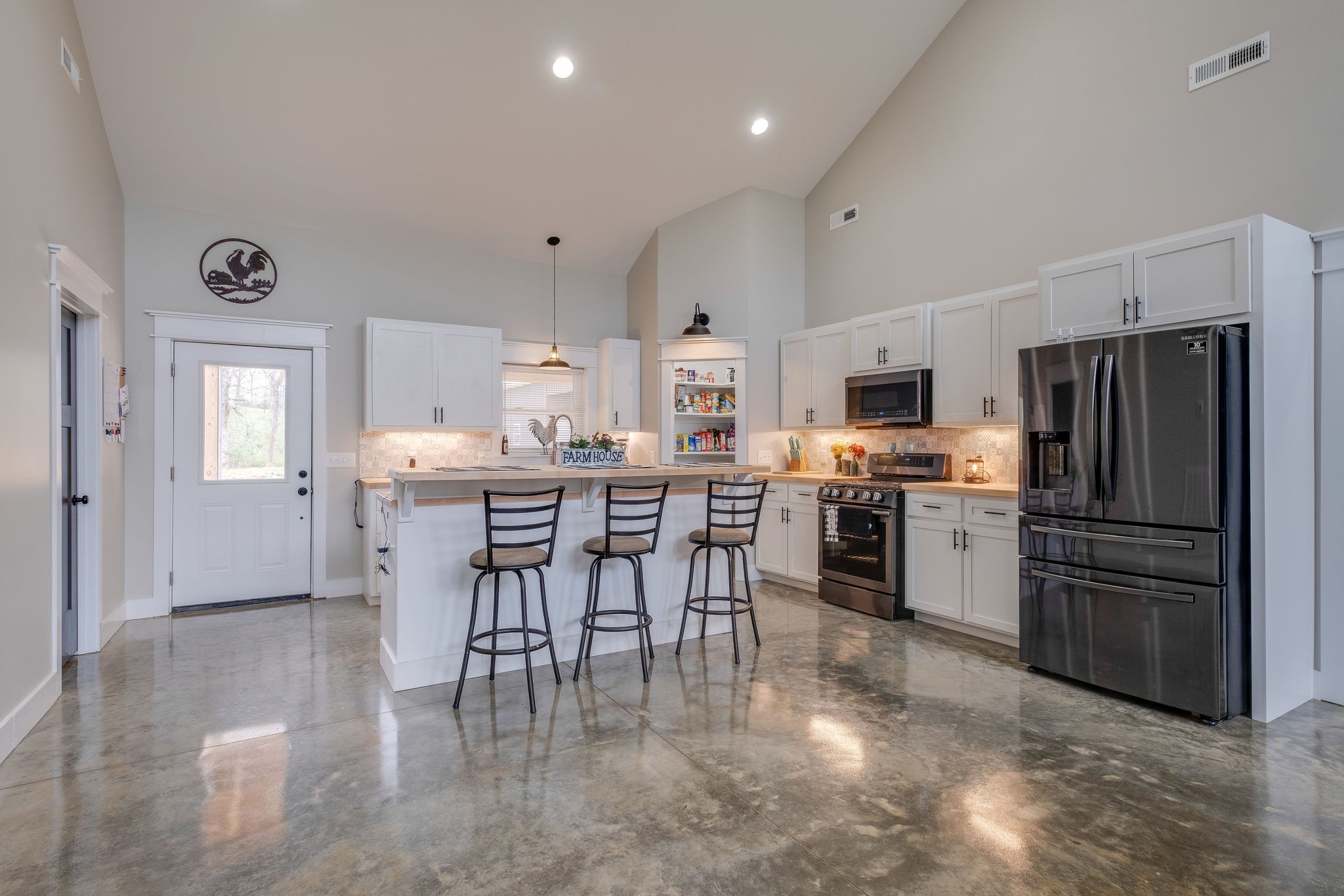 1495 Columbia Road Charlotte, TN 37036 - Photo 7 of 50 a kitchen with stainless steel appliances a refrigerator a stove a sink a dining table and chairs