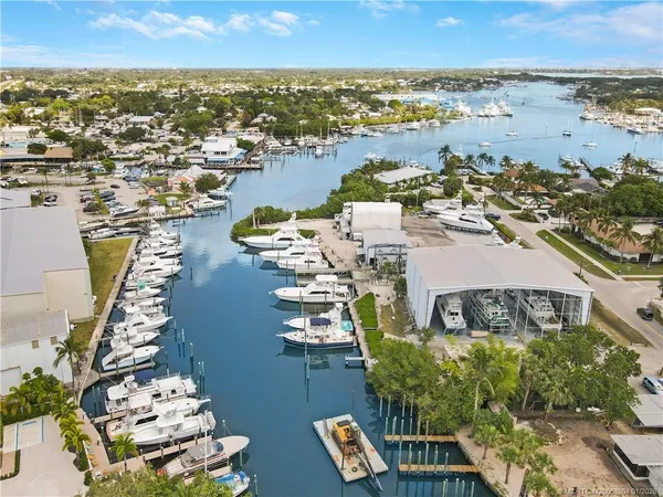 an aerial view of ocean and residential houses with outdoor space