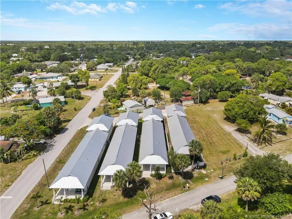 an aerial view of residential houses with outdoor space and trees