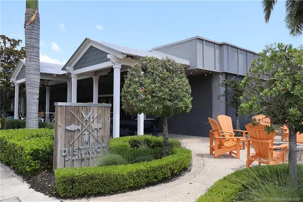 a front view of a house with garden and trees