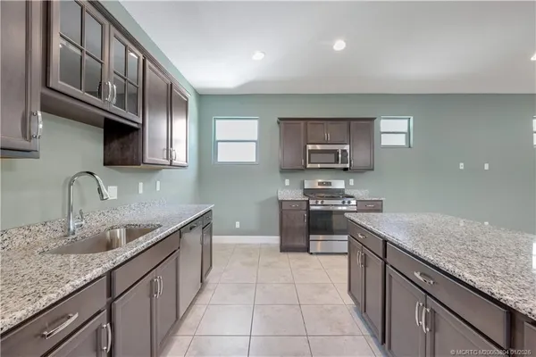 a kitchen with stainless steel appliances granite countertop a sink stove and cabinets