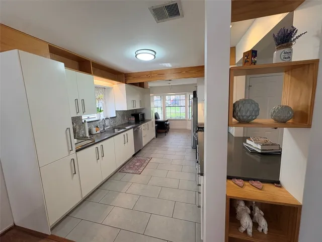 a kitchen with stainless steel appliances a refrigerator sink and cabinets