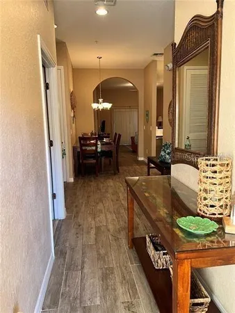 a living room with furniture kitchen view and a chandelier