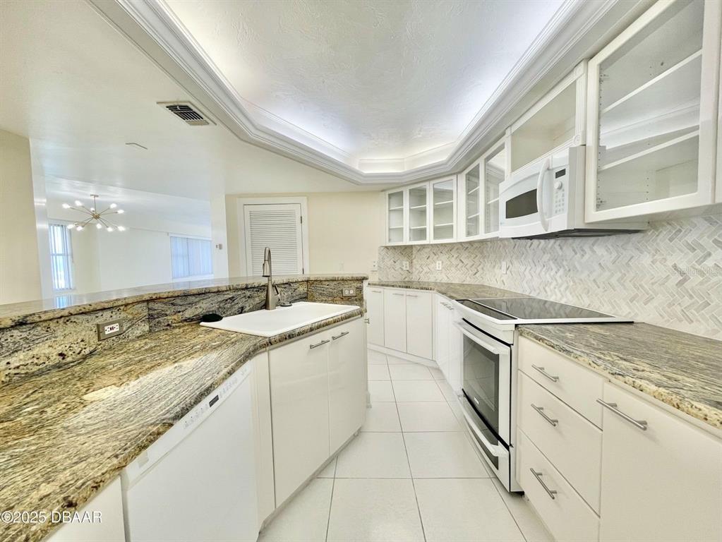 4575 South Atlantic Avenue, Unit 6203 Ponce Inlet, FL 32127 - Photo 15 of 34 a kitchen with granite countertop a sink and cabinets