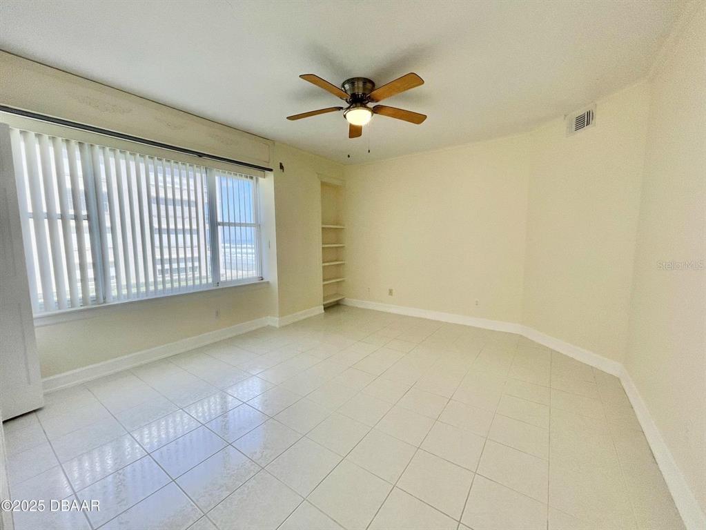4575 South Atlantic Avenue, Unit 6203 Ponce Inlet, FL 32127 - Photo 18 of 34 an empty room with a ceiling fan and window