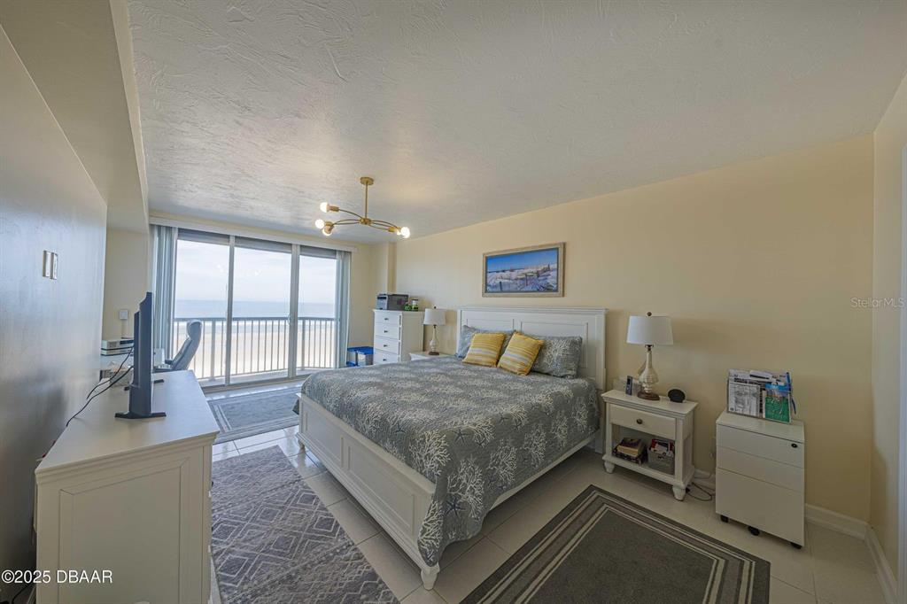 4575 South Atlantic Avenue, Unit 6203 Ponce Inlet, FL 32127 - Photo 10 of 34 a bedroom with a bed and large windows