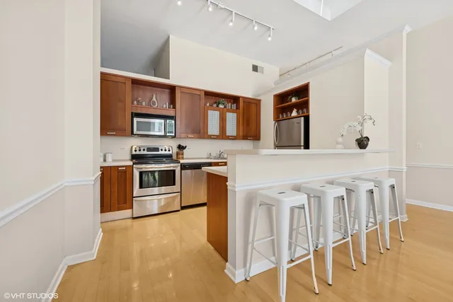 a kitchen with stainless steel appliances granite countertop a stove microwave and refrigerator