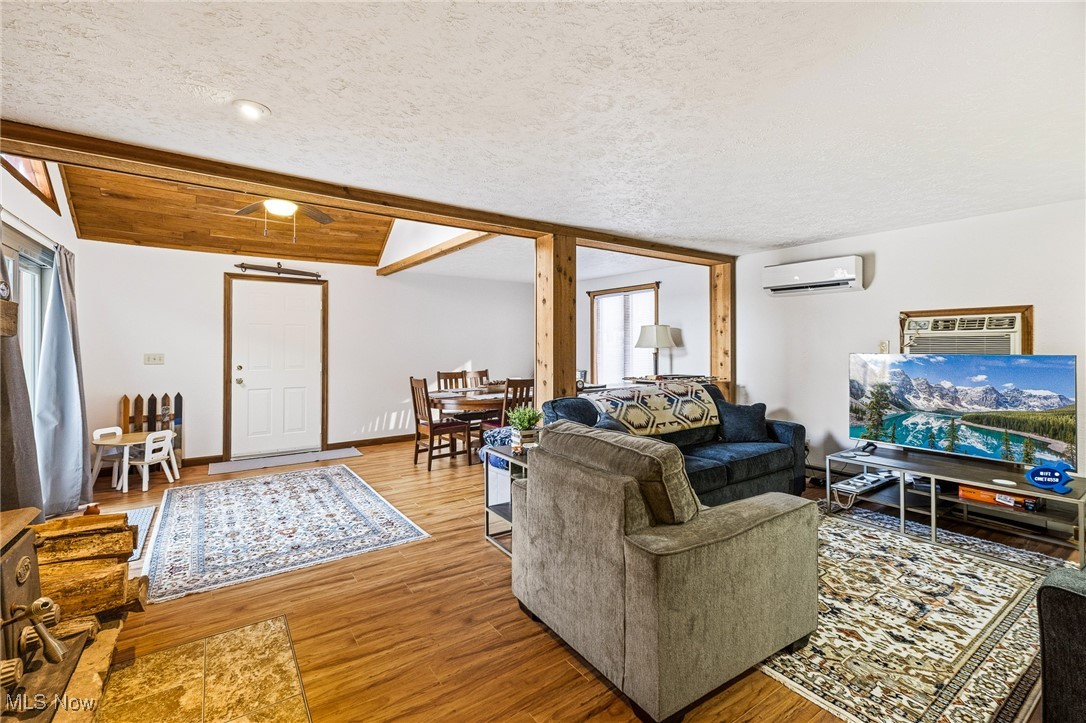 86523 North Bay Road Scio, OH 43988 - Photo 12 of 25 Living area featuring wood finished floors, a textured ceiling, and a wall mounted air conditioner