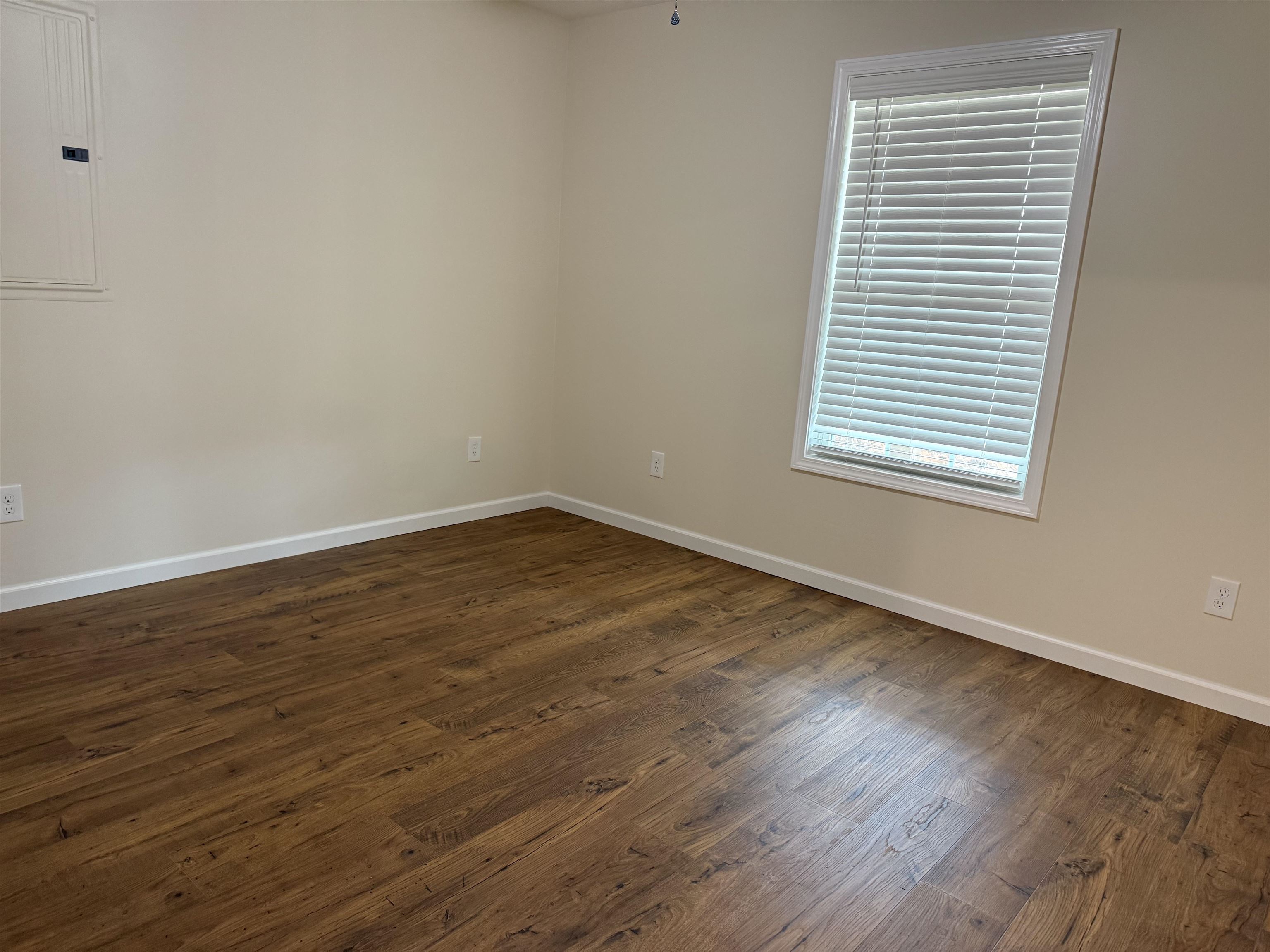 104 Young Drive Selmer, TN 38375 - Photo 4 of 12 an empty room with wooden floor and a window