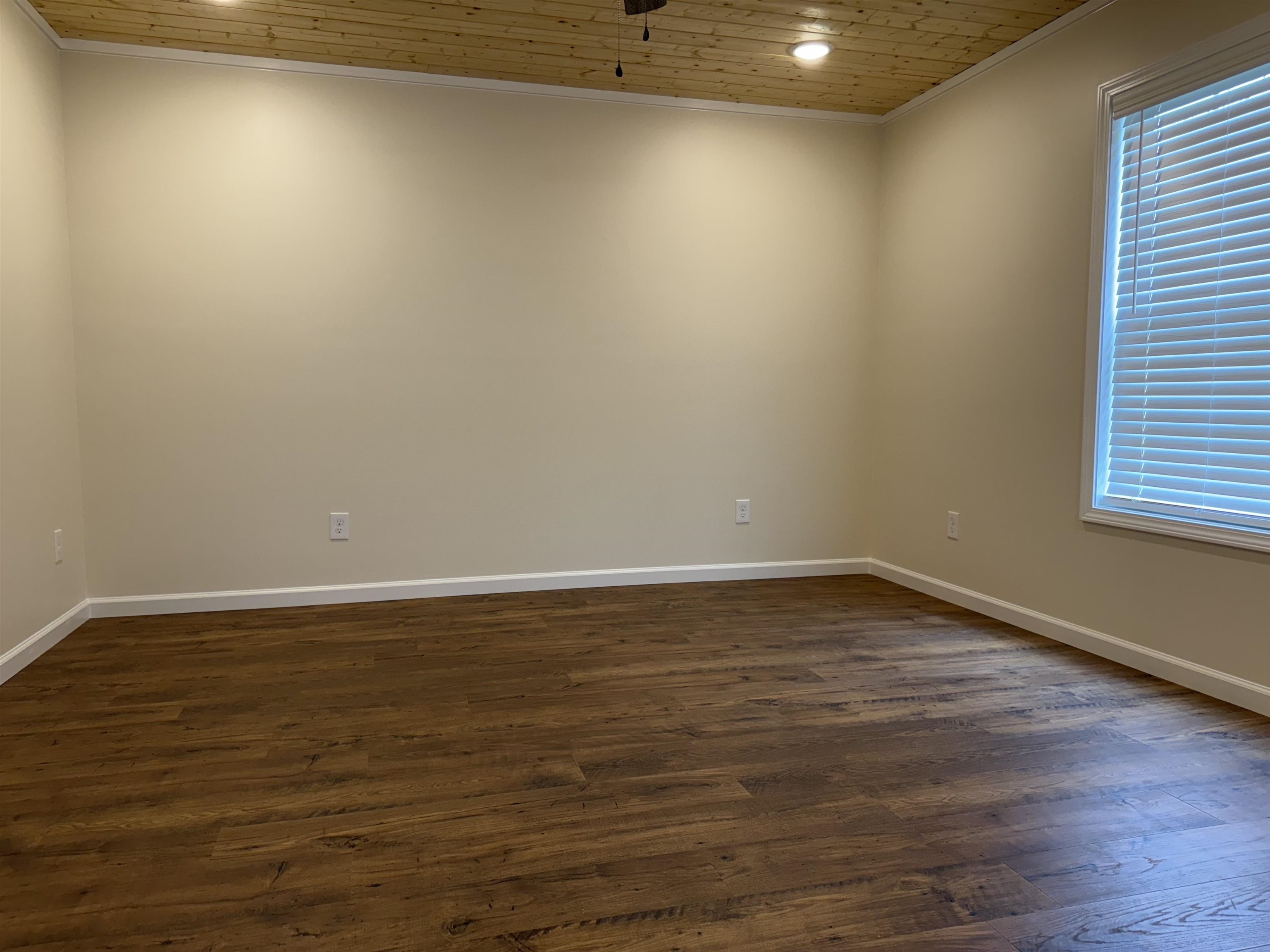 104 Young Drive Selmer, TN 38375 - Photo 8 of 12 a view of an empty room with wooden floor and a window