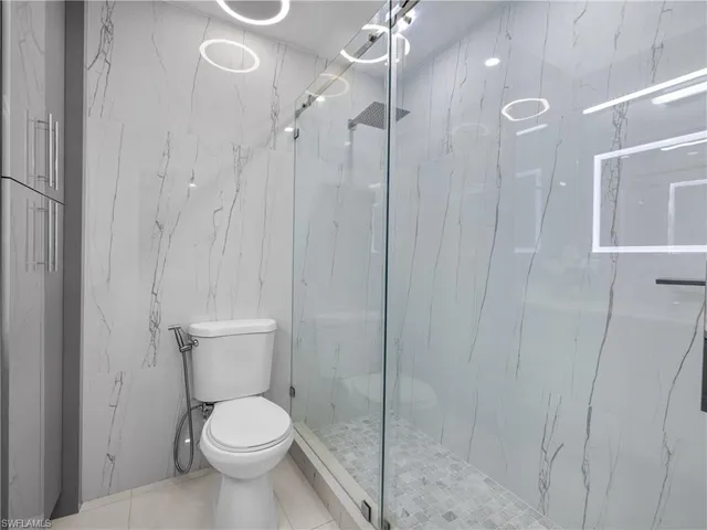 a white toilet sitting next to a shower