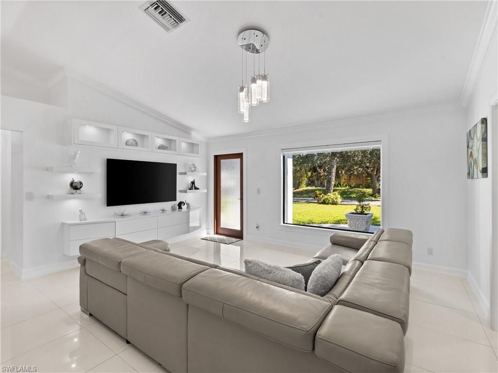1837 51st Terrace Southwest Naples, FL 34116 - Photo 2 of 35 Living area features: picture window, vaulted ceiling, crown molding and recessed lights, custom built in entertainment center.
