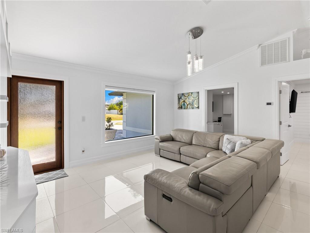 1837 51st Terrace Southwest Naples, FL 34116 - Photo 3 of 35 Living area features: picture window, vaulted ceiling, crown molding and recessed lights.