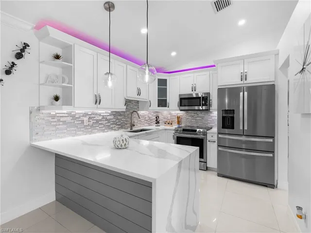 a kitchen with kitchen island a sink stainless steel appliances and cabinets