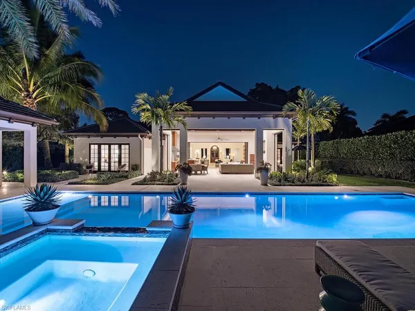 a view of a house with swimming pool and sitting area